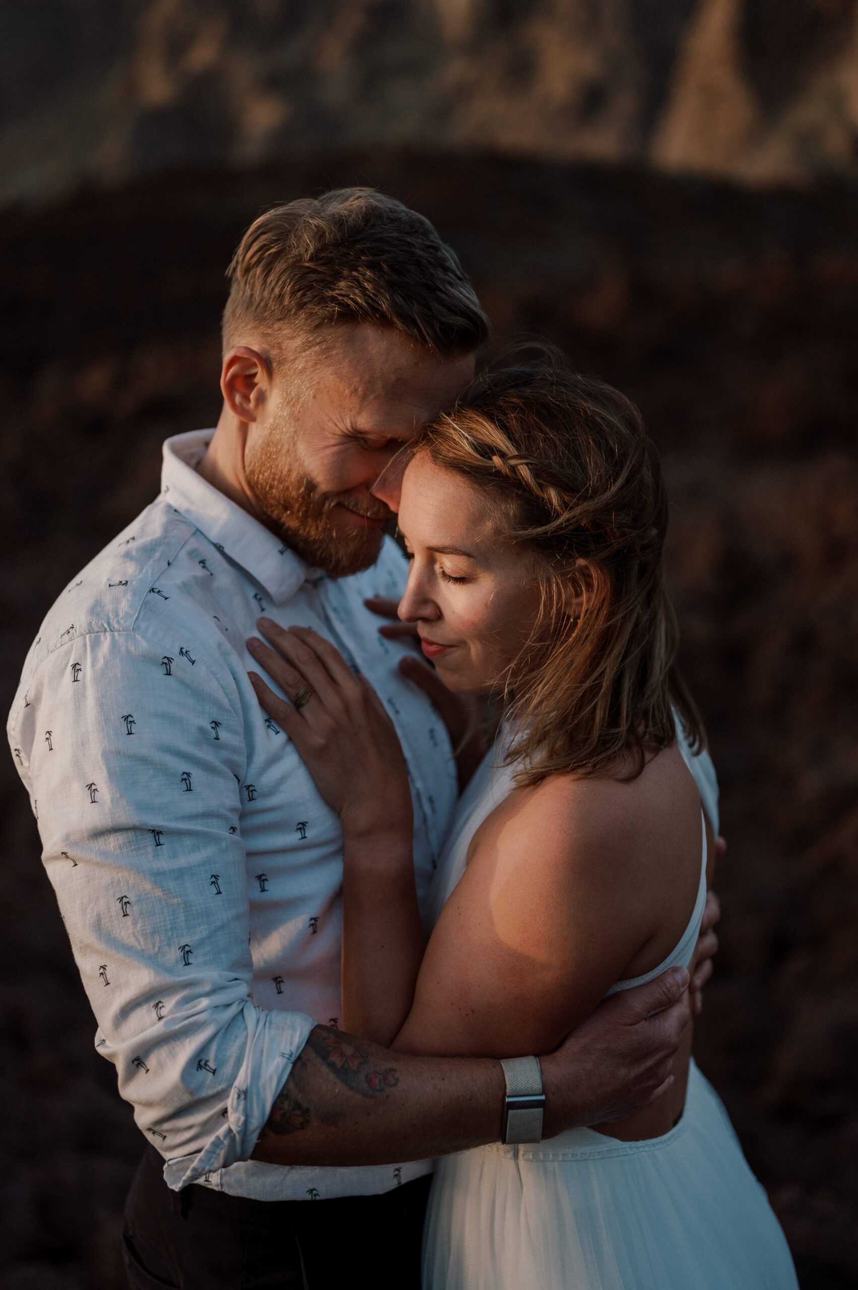 close up from a wedding couple that is standing close together on a mountain during sunset