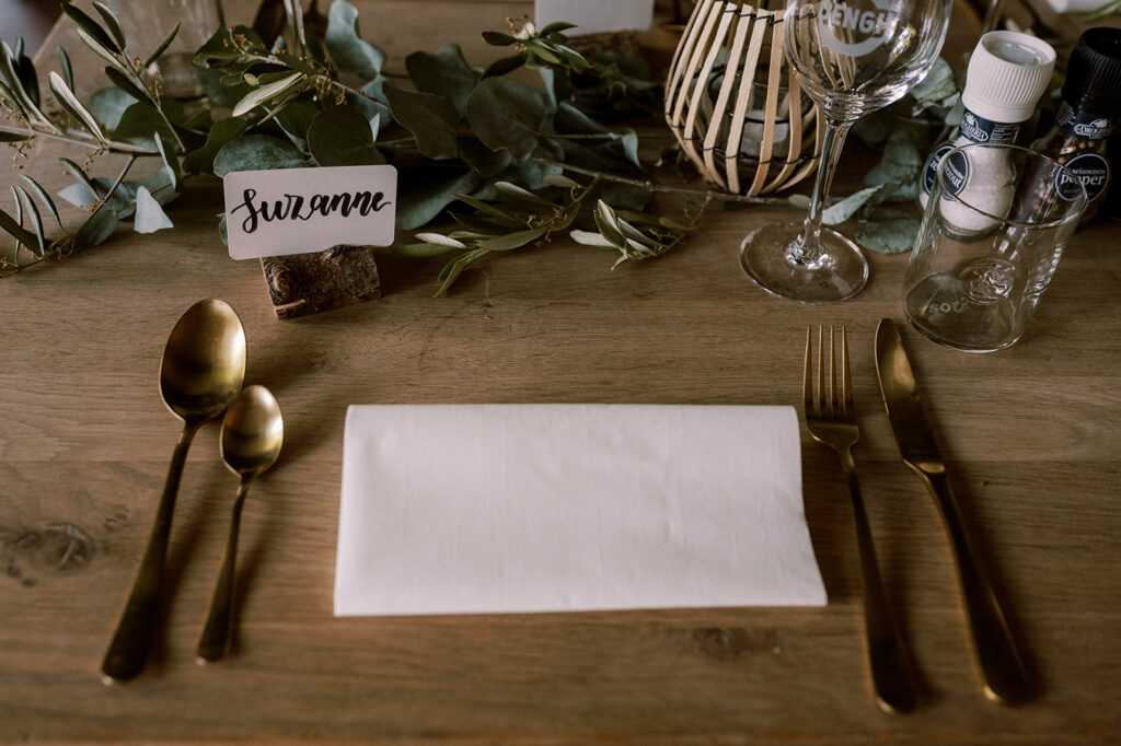 naamkaartje en gouden bestek van tafelstyling van een bruiloftsdiner